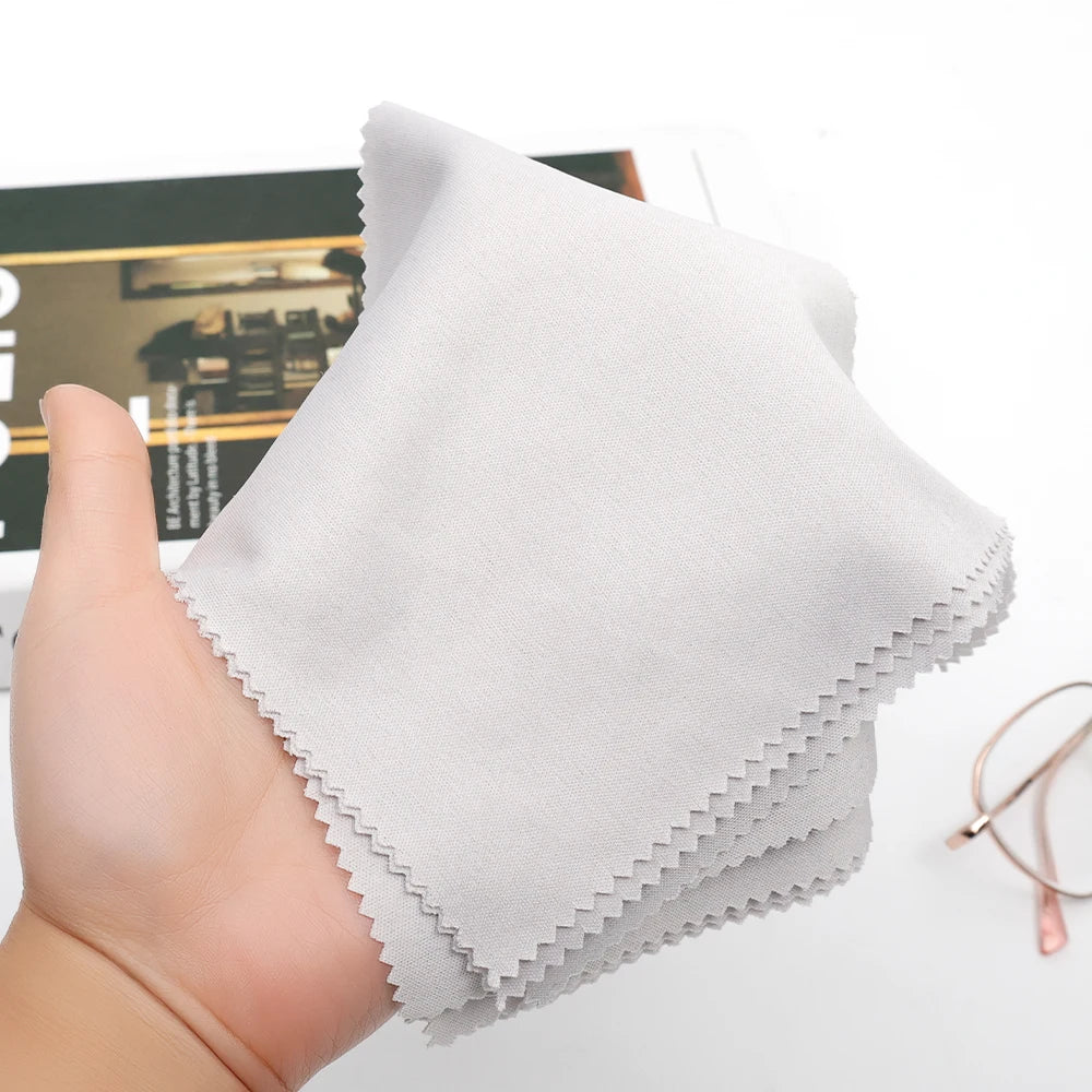 Hand holding a white cleaning cloth with a blurred background